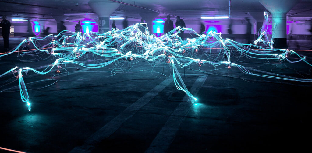 Credentials Unbound - Picture shows an art installation in an open space with wires and lights connecting to each other resembling lightning across the floor